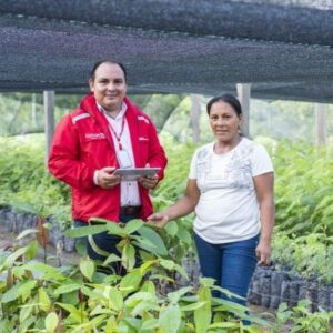 funcionario de Bancamia con una señora y un señor en un cultivo
