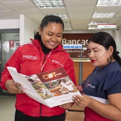 Funcionaria mostrando una cartilla de CDT social a una señora