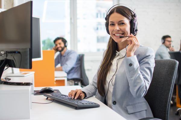 Mujer sonriendo en la oficina con audifonos