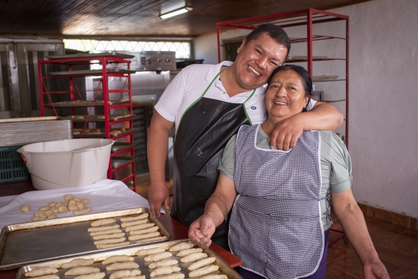 Mujer y hombre abrazandose felices, cocinando en una panaderia