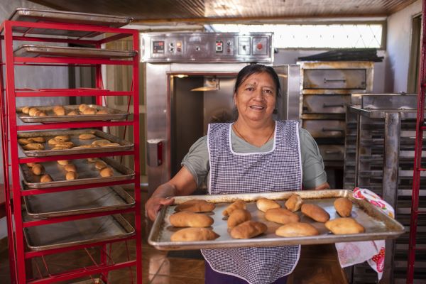 Señora mostrando el pan en una panaderia
