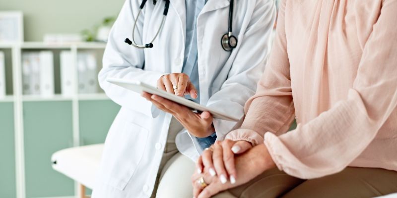 Doctora mostrando una tablet a paciente con wikidoc