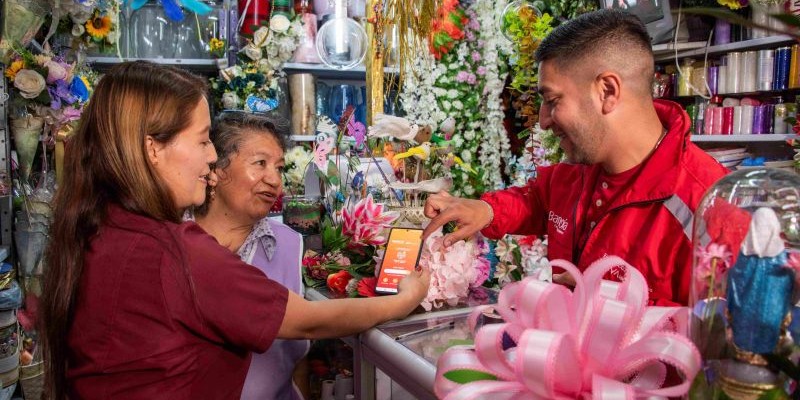 mujeres tenderas atienden a señor - dia del tendero